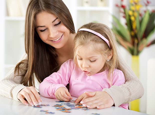 photo of a student and teacher putting a puzzle together