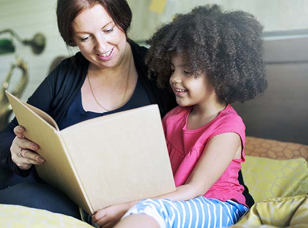 photo of a student and teacher looking at a book